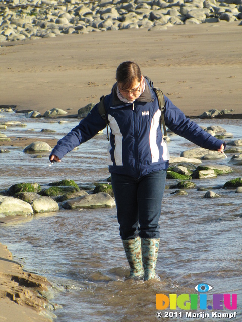 SX17195 Jenni walking through stream on Llantwit Major beach